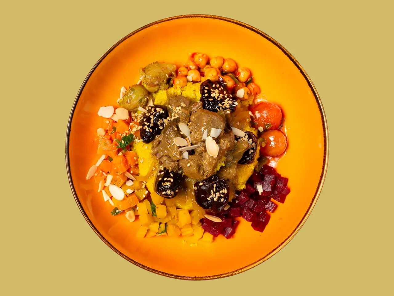 Tausendundeine Nacht Bowl von oben: geschmortes Rindfleisch, Kichererbsen und Mandeln auf einem orangefarbenen Teller